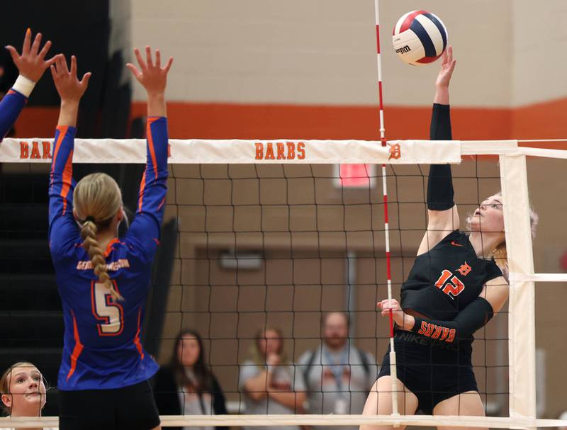 DeKalb's Isabelle Smith tries to spike the ball by Genoa-Kingston's Savannah Beisner during their match Wednesday, Sept. 10, 2025, at DeKalb High School.