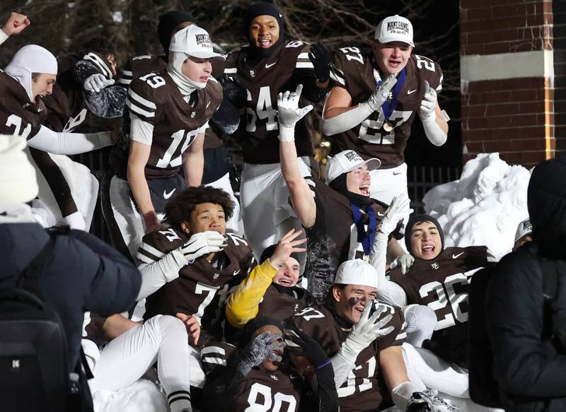 Mount Carmel players celebrate in the snow Wednesday, Dec. 3, 2025, after their win over Oswego in the IHSA Class 8A state chamionship game in Huskie Stadium at Northern Illinois University in DeKalb.