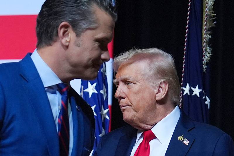 President Donald Trump is greeted by Secretary of Defense Pete Hegseth before speaking to a gathering of top U.S. military commanders at Marine Corps Base Quantico, Tuesday, Sept. 30, 2025, in Quantico, Va. (AP Photo/Evan Vucci)