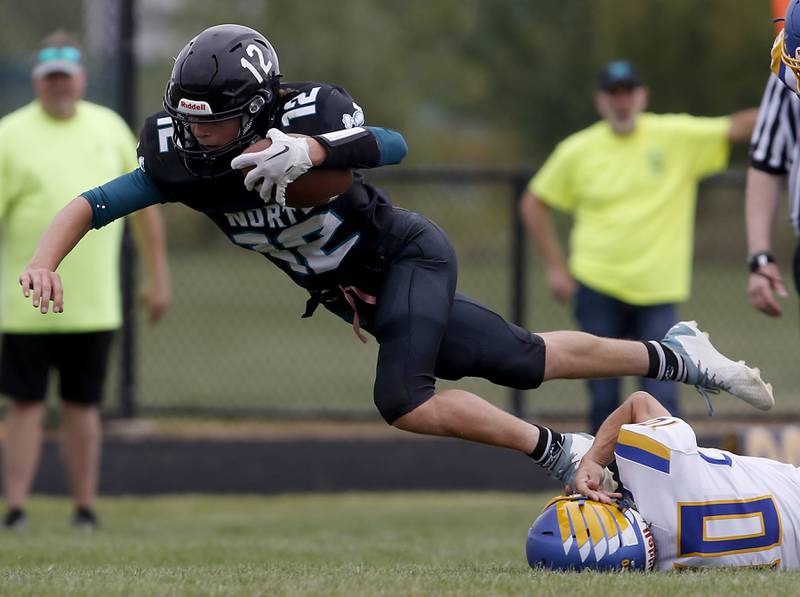 Woodstock North's Landan Creighton tries to get a fell extra yards as he is tackled by Johnsburg's Chuck Ravenscraft during a Kishwaukee River Conference football game Saturday, Aug. 26, 2023, at Woodstock North High School.