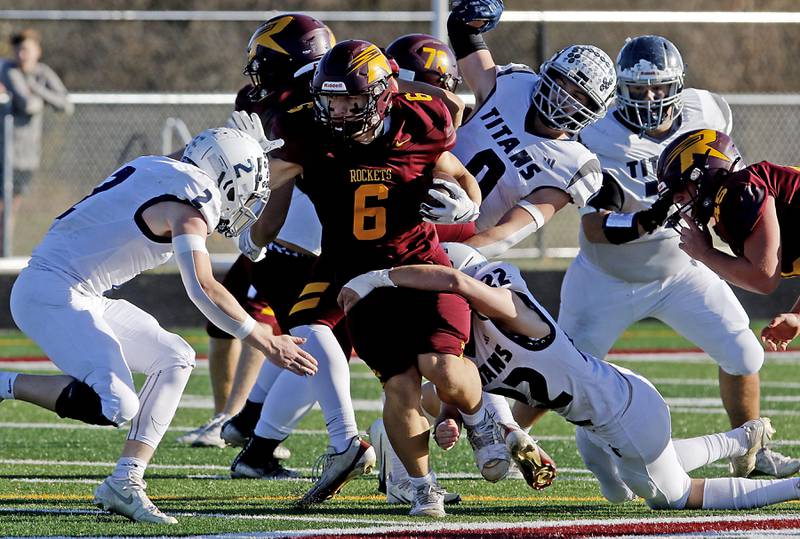 Richmond-Burton's Hunter Carley tries to run between Monmouth-Roseville's Andrew Way (left) and  Asa Braun (right) during an IHSA Class 3A quarterfinal playoff football game on Saturday, November 15, 2025, at Richmond-Burton High School, in Richmond.