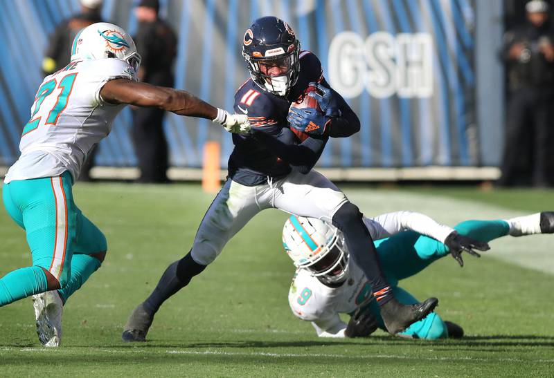 Chicago Bears wide receiver Darnell Mooney tries to get free from Miami Dolphins safety Eric Rowe and cornerback Noah Igbinoghene during their game Sunday, Nov. 6, 2022, at Soldier Field in Chicago.