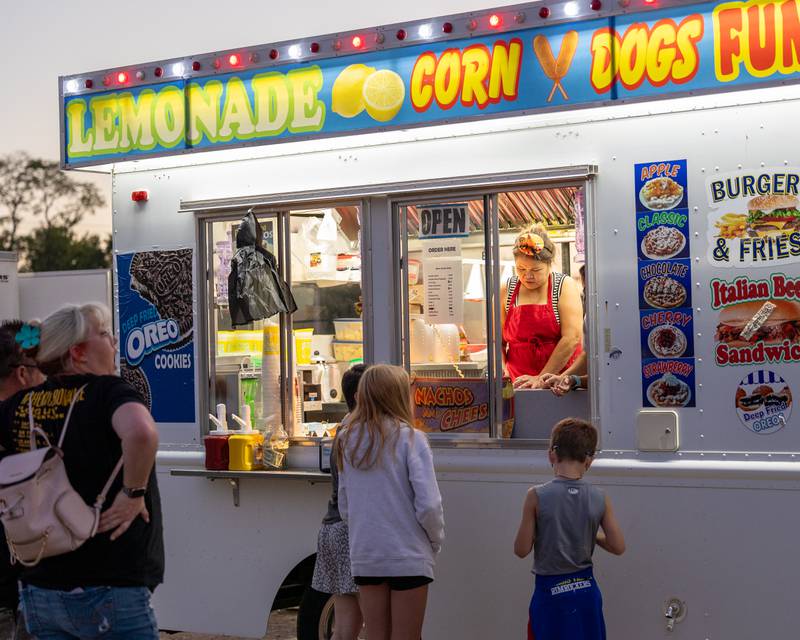 Kids buy corndogs from food trailer at the Monster Mash Balloon Bash on Saturday, Oct. 4, 2025 at the Bureau County Fairgrounds in Princeton.