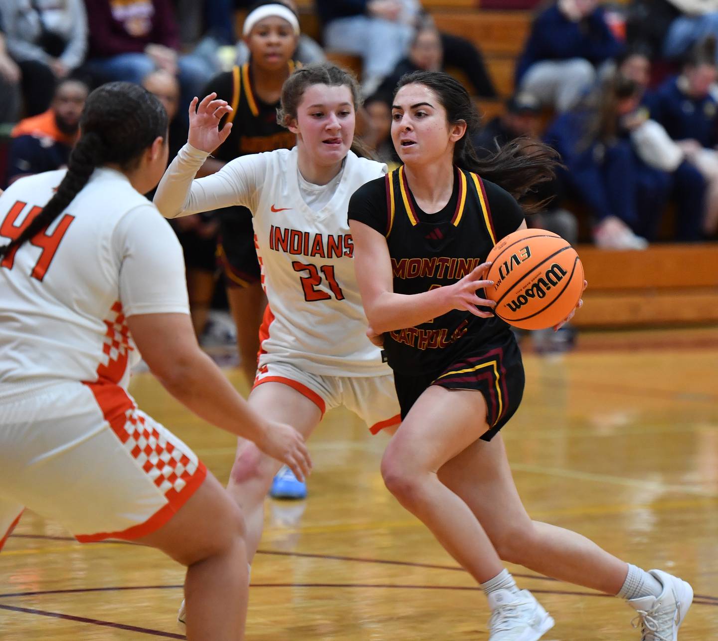 Montini’s Mia Quaranta drives to the basket as Minooka’s Sadie Webb (21) and Jaelle Hamilton (44) defend during a Montini Christmas Tournament game on December 22, 2025 at Montini Catholic High School in Lombard.
