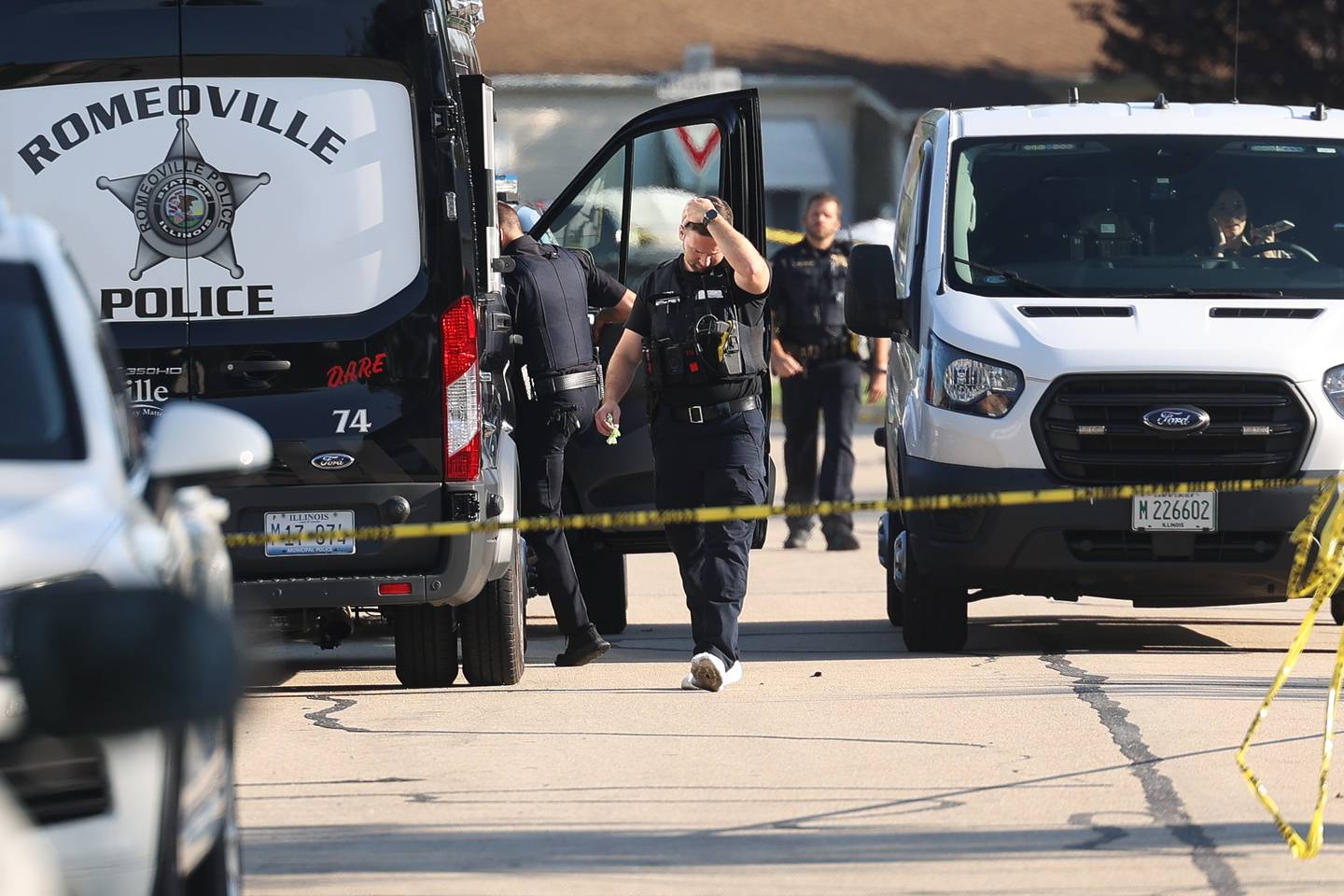 Police officers stage outside a home on the 500 block of Concord Avenue where police found the bodies of two adults and two children with gunshot wounds on Monday, Sept. 18, in Romeoville.