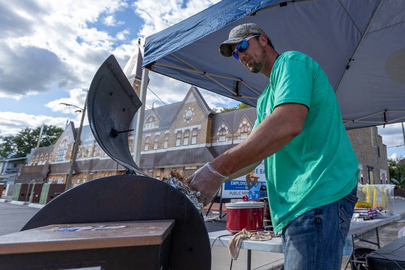 Richie Scott gets pulled pork from smoker at Reid's Smokehouse' tent on Monday, Aug 25, 2025 on Illinois Avenue in Mendota.