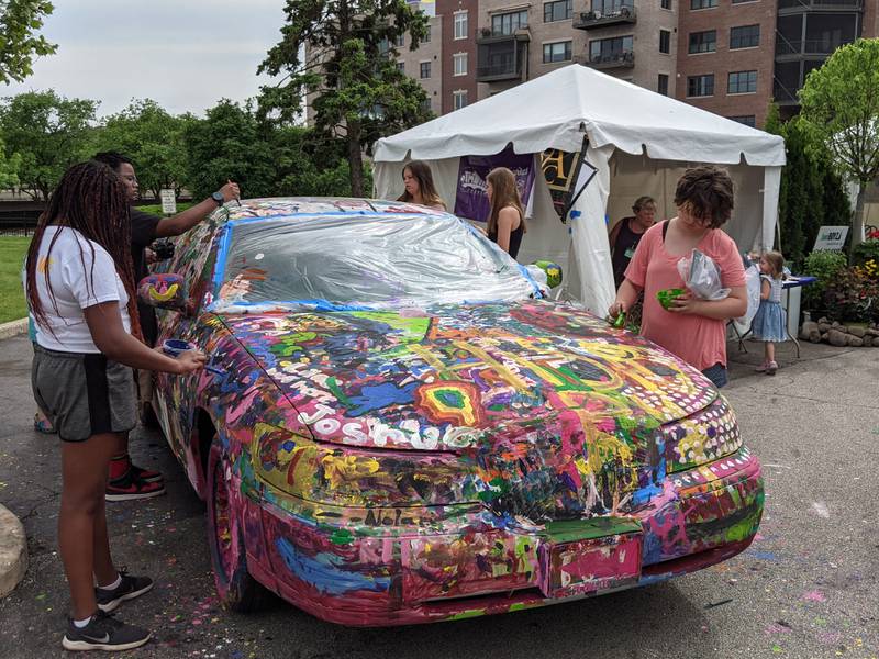 Ella Garcea, right, was helping painting a car Sunday at the St. Charles Fine Art Show.