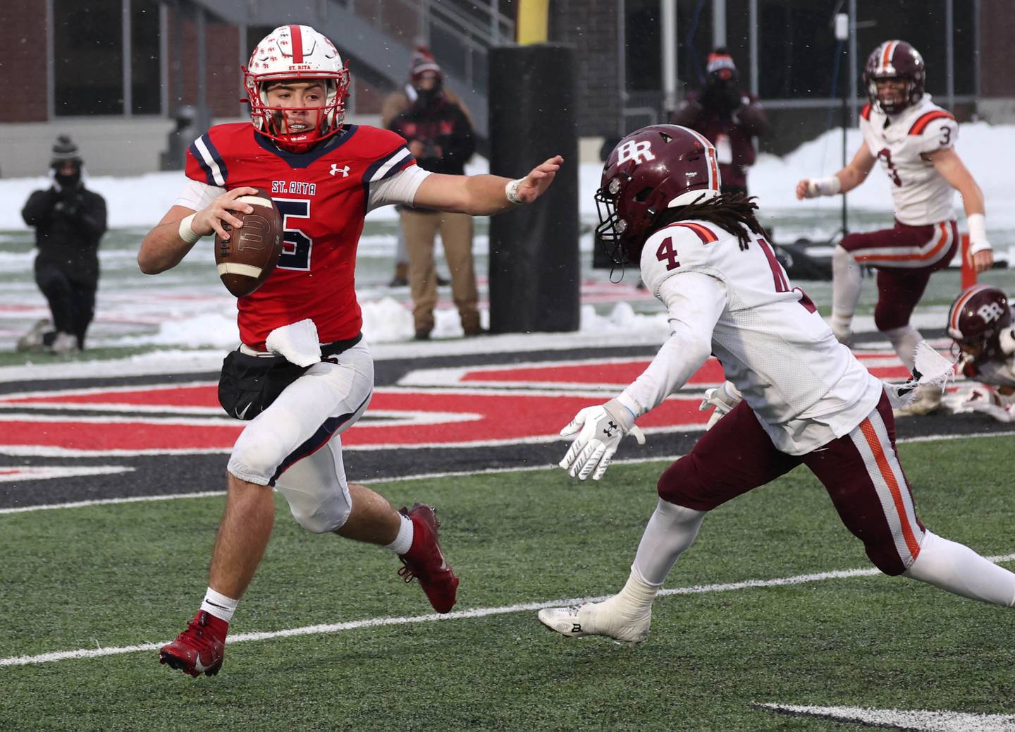 St. Rita's Steven Armbruster tries to hold off Brother Rice's Javeyon Lockett Wednesday, Dec. 3, 2025, during their IHSA Class 7A state chamionship game in Huskie Stadium at Northern Illinois University in DeKalb.