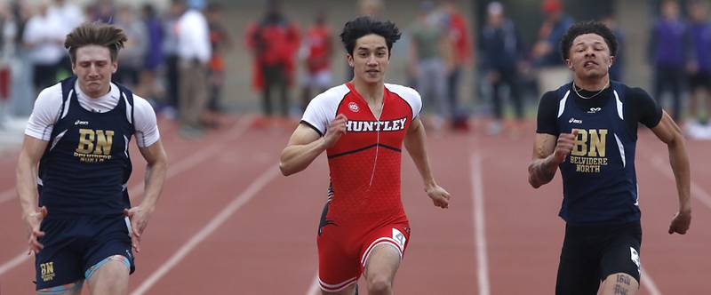 Huntley’s Evan Gronewold, center, battles Belvidere North’s Nico Bertolino, left, and Tristen Powers, right, in the 100 meter dash during the IHSA Class 3A Huntley Boys Track and Field Sectional Wednesday, May 18, 2022, at Huntley High School.