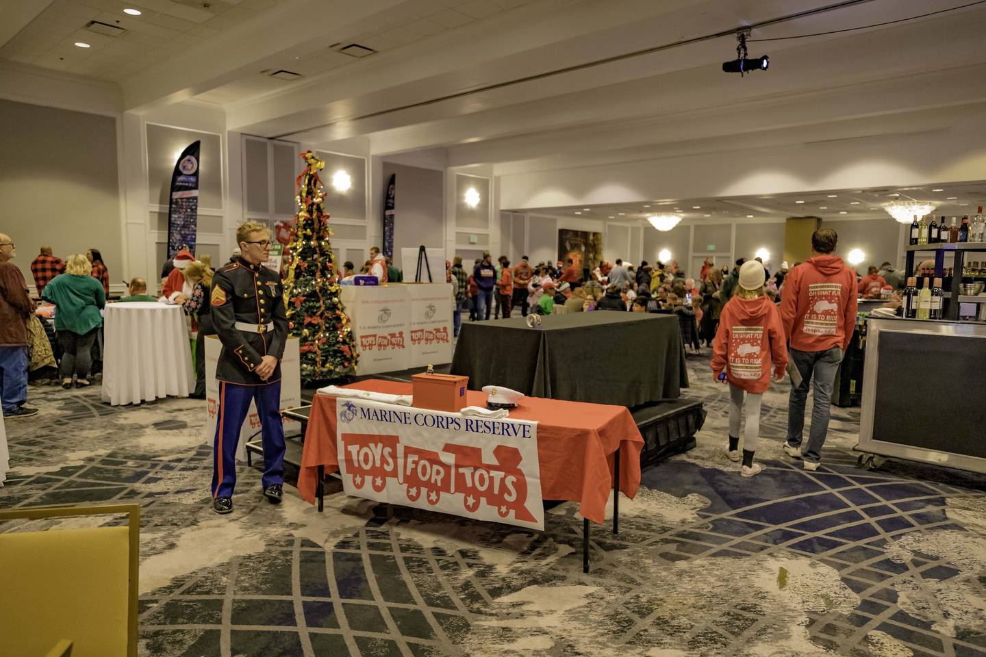 A young Marine mans the U.S. Marine Corps Reserve Toys for Tots Program table during the 2024 Jeeps on the Run Toys for Tots Run after-party at the Lincolnshire Marriott Resort.
