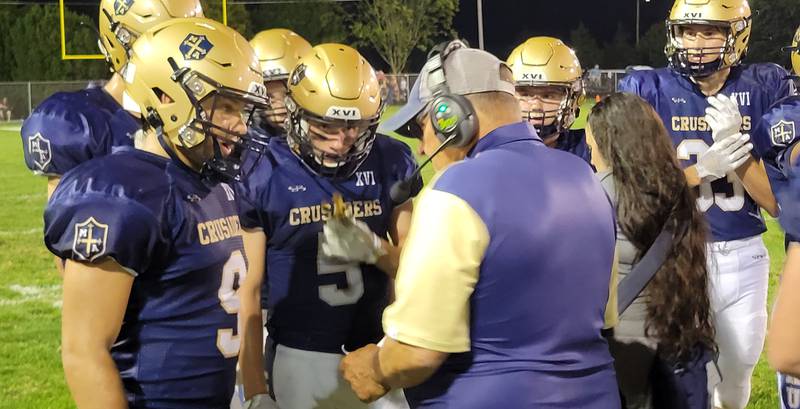 Marquette coach Tom Jobst gives instructions to quarterback Alex Graham, back Tommy Durdan and others during a timeout in Friday's 41-0 win over Chicago Christian in Ottawa.