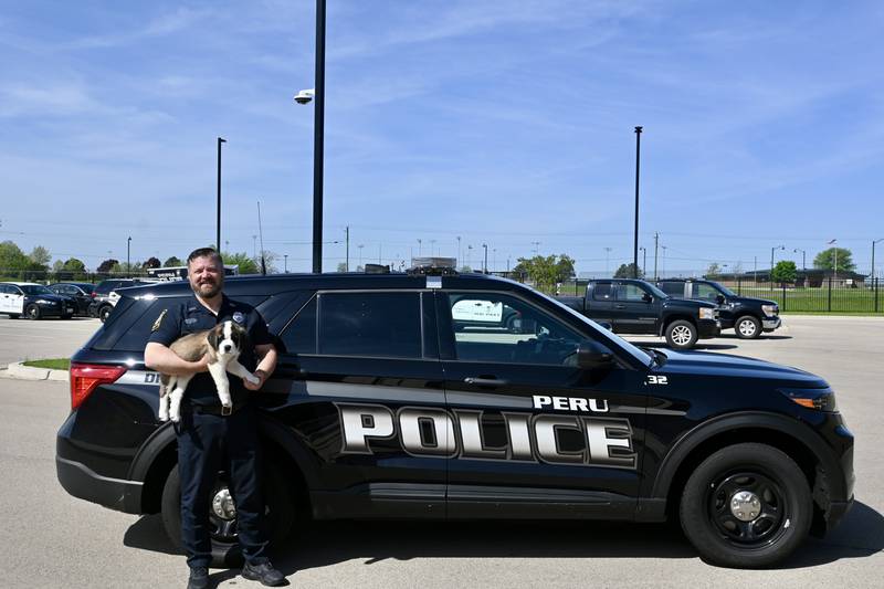 School Resource Officer Brian Zebron holds  Peru's newest recruit Haven.