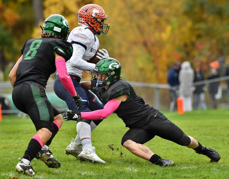 Glenbard West's Will Meyer (right) tackles Naperville North's Cole Arl (1) for a loss as teammate Eli Limouris (8) moves in to help during an IHSA Class 8A playoff game on Oct. 28, 2023 at Glenbard West High School in Glen Ellyn.