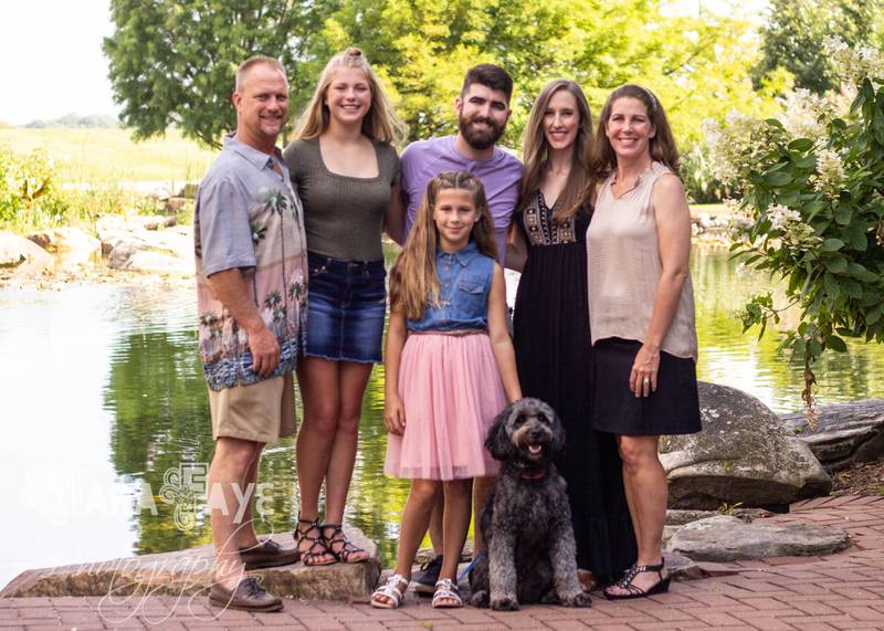 The family of Anthony "AJ" Pantaleo, 27, gather over Labor Day weekend 2019. This was the last family photo taken before he committed suicide Nov. 8. Left to right is Pantaleo's stepfather Bob Buelow, Kyleigh Buelow, Anthony "AJ" Pantaleo, his wife, Christina Pantaleo, Heather Buelow, and Brianna Buelow (center) with AJ's dog Cooper.