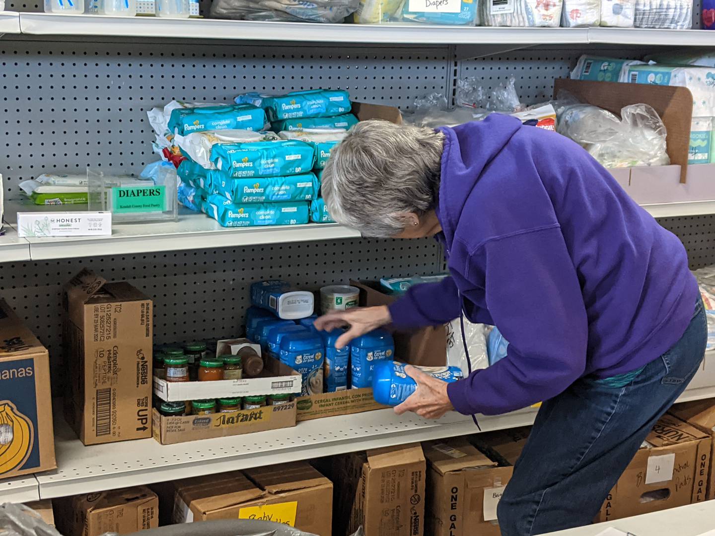 Kendall County Community Food Pantry volunteer Darlene Kuehl stocks shelves at the pantry prior to the pantry's distribution day on Thursday, Oct. 30, 2025.