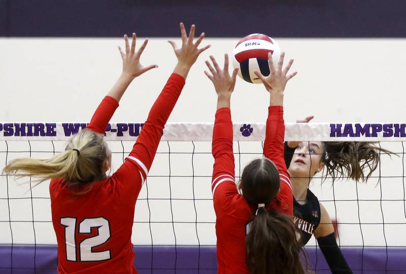 Libertyville's Claire Evans (right) hits the ball into the block of Huntley's Summer Massow (left) and achael Hein (center) during an IHSA Class 4A Hampshire Sectional semifinal volleyball match on Tuesday, Nov. 4, 2025, at Hampshire High School.