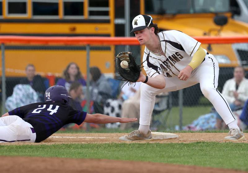 Dixon’s Brady Feit dives back to first safely as Sycamore's Davis Collie takes the throw on a pickoff attempt Thursday, May 29, 2025, during their Class 3A regional semifinal game at Freeport High School.