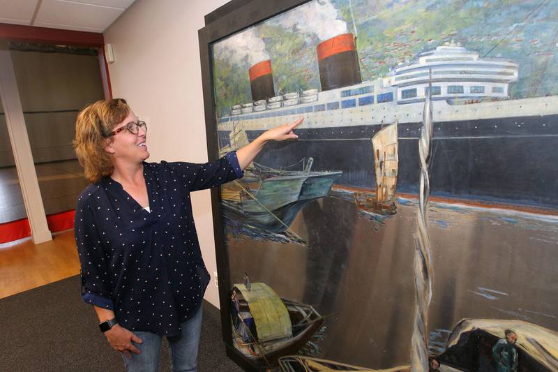 Candace H. Johnson for Shaw Local News Network
Amy Whitis, interim Parks & Recreation manager, points out the details of the Buell Mullen mural on display at the Lakefront Park building in Fox Lake. The mural titled, "Hong Kong," features a view of the Hong Kong harbor and is on loan from the National Museum of the American Sailor. It is approximately 20 ft. long and six-feet high on stainless steel and weighs about 600 pounds. This is one of a two pieces in a mural set with the other piece on display at the County Building in downtown Waukegan. (10/31/22)