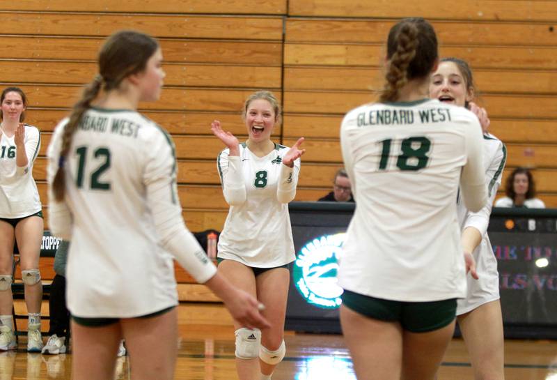 Glenbard West’s Avery Herbert (center) celebrates a point with her team during a home game against Lyons Township in Glen Ellyn on Tuesday, Oct. 10, 2023.