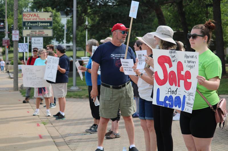 Attendees rally for reproductive rights during a protest on Monday, July 4, 2022 at the corner of First Street and Lincoln Highway in downtown DeKalb. The Independence Day gathering was organized to protest a recent ruling by the U.S. Supreme Court to overturn Roe v. Wade, which protected access to abortion under federal law.