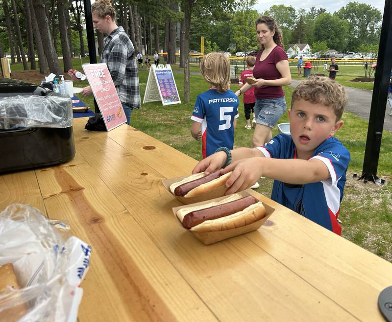 Knox Benesh, 7, of Oregon, snags a free hot dog after his ball game during the Oregon Park District's Grand Opening celebration for Park East Inland Side recreation area on Monday, May 18, 2026.