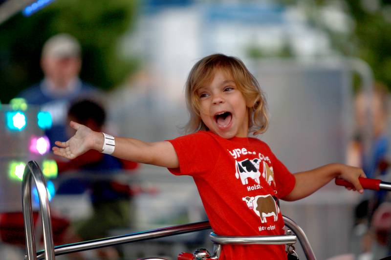 Cassidy Varsho, 4, of Elburn, waves to her family from the motorcycle ride during the 156th Annual Kane County Fair on Thursday, July 17, 2025 in St. Charles. The fair runs through Sunday, July 20, 2025.