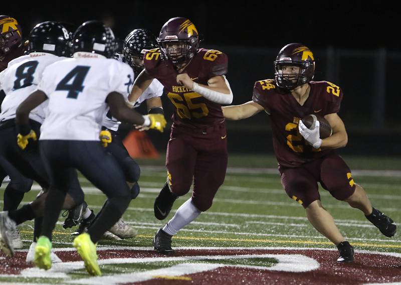 Richmond-Burton's Hunter Carley runs behind the block of his teammate, Trevor Szumanski, during a Kishwaukee River Conference football game against Woodstock North on Friday, Oct. 11, 2024, at Richmond-Burton High School.