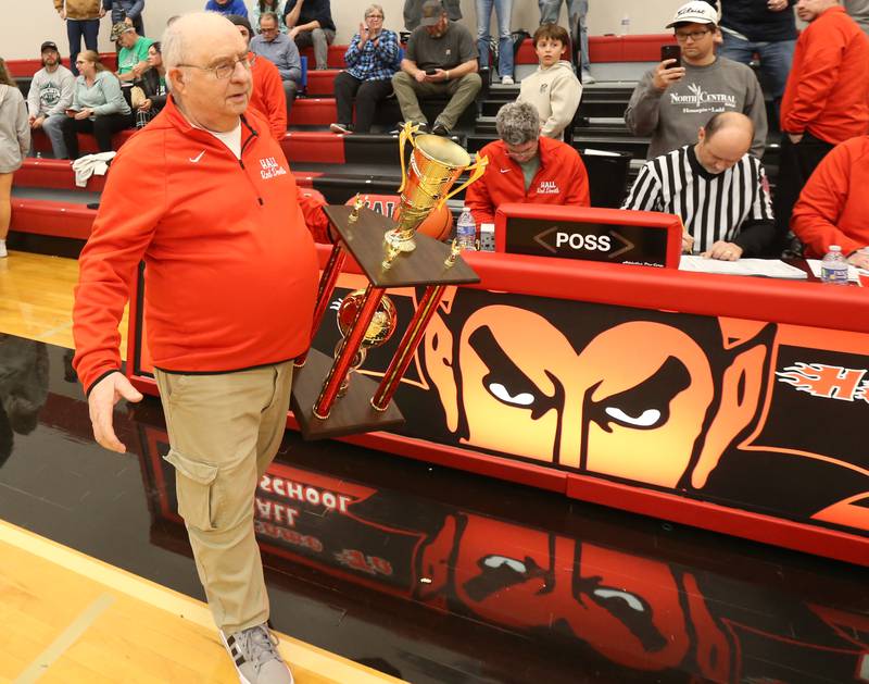 Frank Colmone walks past the scores table with the first-place trophy during the 49th annual Colmone Classic on Saturday, Dec. 9, 2023 at Hall High School.