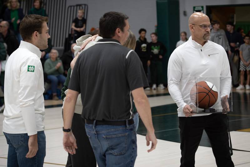 Bishop McNamara's head coach Adrian Provost, right, is presented with a ceremonial basketball for his last McNamara home game on Friday, Feb. 20, 2026.