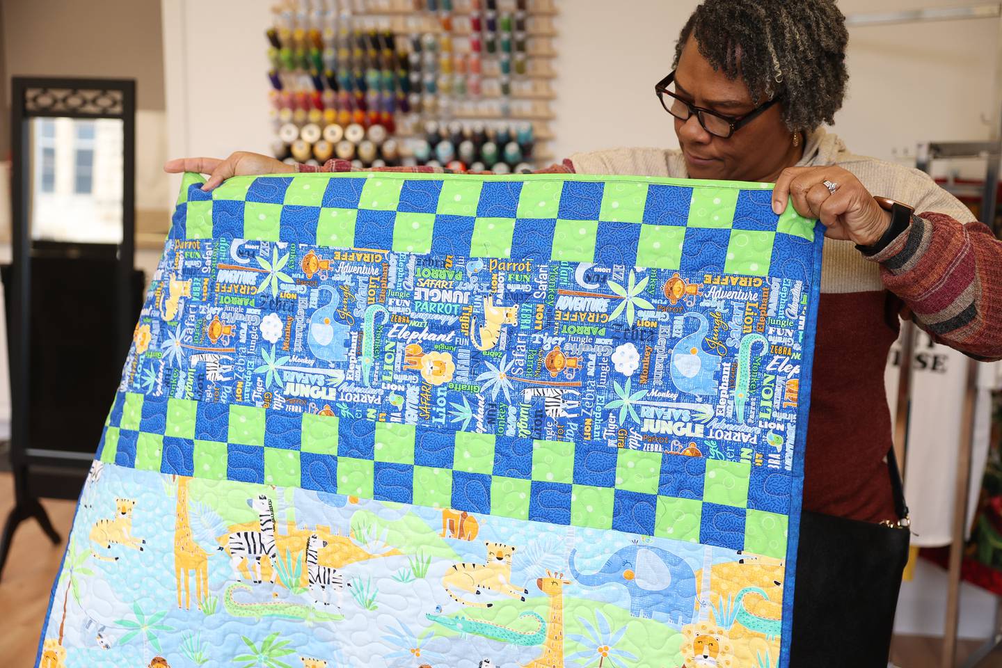 Diedra Hills, one of the ‘Sewing Sistas’, shows off a quilt they made at The Sewing Cafe on Thursday, Jan. 25th, 2024 in Joliet.