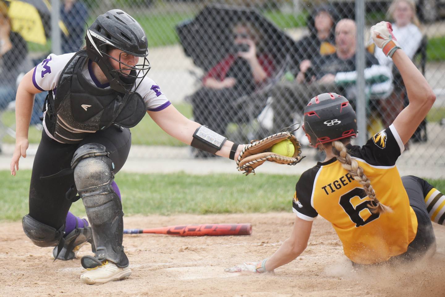 Manteno's Ginny Kvasnicka, left, reaches to apply a late tag as Herscher's Lexi Crawford slides into home for a run during a game at Manteno Tuesday, May 12, 2026.