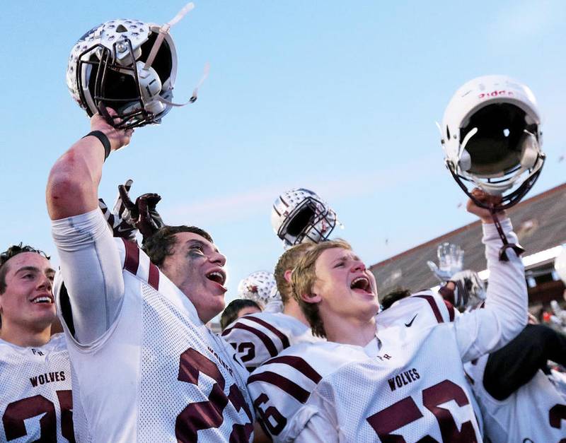 Prairie Ridge players including Sampson Evans (left) and Scott Nygren celebrate the Wolves 48-17 win against Sacred Heart-Griffin in the Class 6A football state championship Saturday.