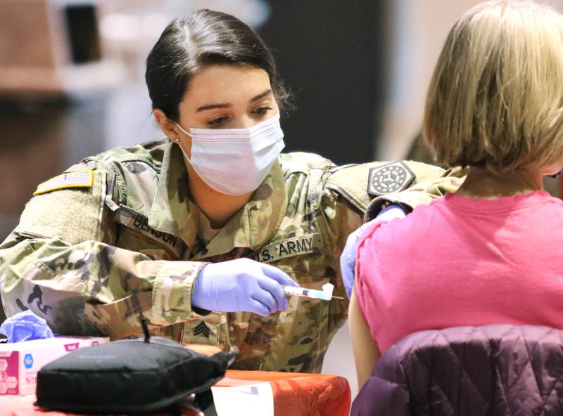 A member of the Illinois National Guard administers the COVID-19 vaccine Wednesday at the Convocation Center at Northern Illinois University in DeKalb.