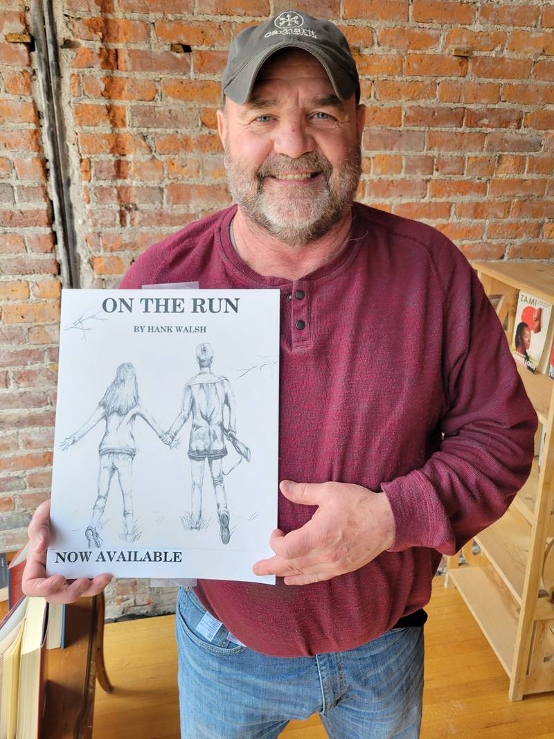 Ottawa's Hank Walsh proudly displays a poster featuring his first work of fiction, "On The Run," now available in book stores in Ottawa and Princeton.