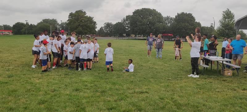 Campers line up for a photo with instructors and NIU defensive backs Eric Rogers, Jordan Gandy and Devin Lafayette on Sunday, July 24, 2022 at the Youth Pride Foundation Skills and Drills Football camp.