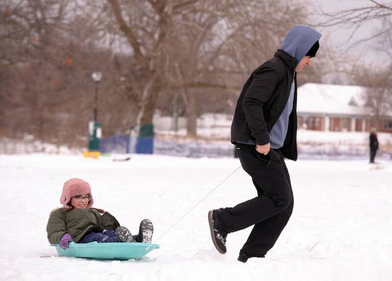Scott Wiley of Chicago brings his niece Hannah Wiley of Wheaton back to the car after a day of sledding at Northside park in Wheaton Saturday, Jan 13, 2024.