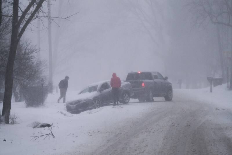 A truck pulls a car out of the ditch along North Marley Road. Heavy snow accumulated quickly making the evening commute hazardous throughout Will County. Thursday, Feb. 17, 2022, in New Lenox.