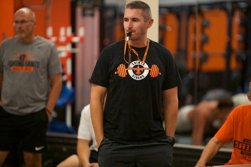 St. Charles East's Coach Nolan Possley blows the whistle for a update as they shelter in place in the weight room on Monday, Aug. 18,2025.