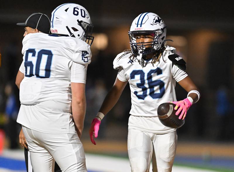 Plainfield South's Kodi Garner (36) celebrates with teammate Jaxon Burnopp (60) after scoring a touchdown during the conference game against Joliet Central on Friday, OCT. 17, 2025, at Joliet.