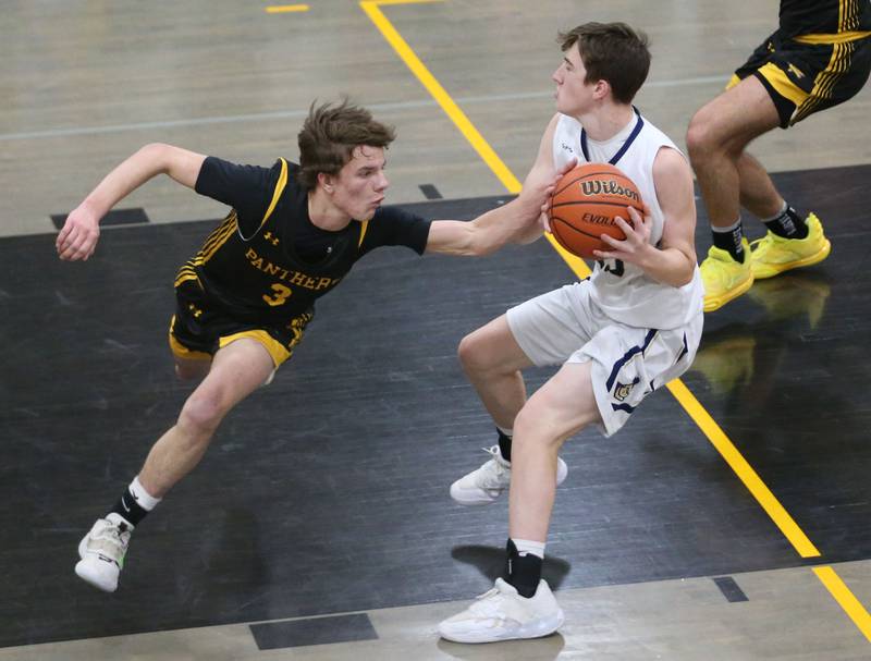 Putnam County's Bryce Smith blocks the ball from Marquette's Griffin Dobberstein during the Tri-County Conference Tournament on Tuesday, Jan. 23, 2024 at Putnam County High School.