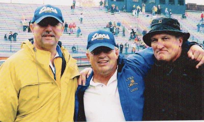 Mark King (center) celebrates with fellow Lyons Township football coaches Mike Stimac (left) and Brian Kopecky after the last game of an undefeated sophomore football season.