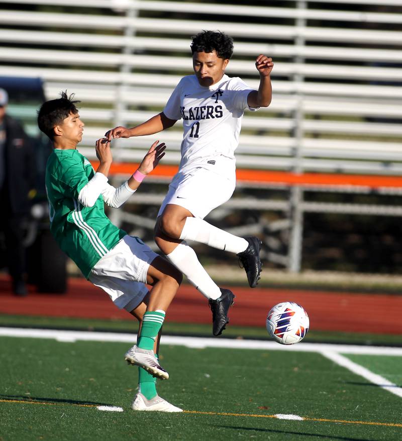 Addison Trail’s Christopher Ortega (11) gets the ball in the air over York’s Gustavo Herrera during a Class 3A St. Charles East Sectional semifinal game on Wednesday, Oct. 26, 2022.