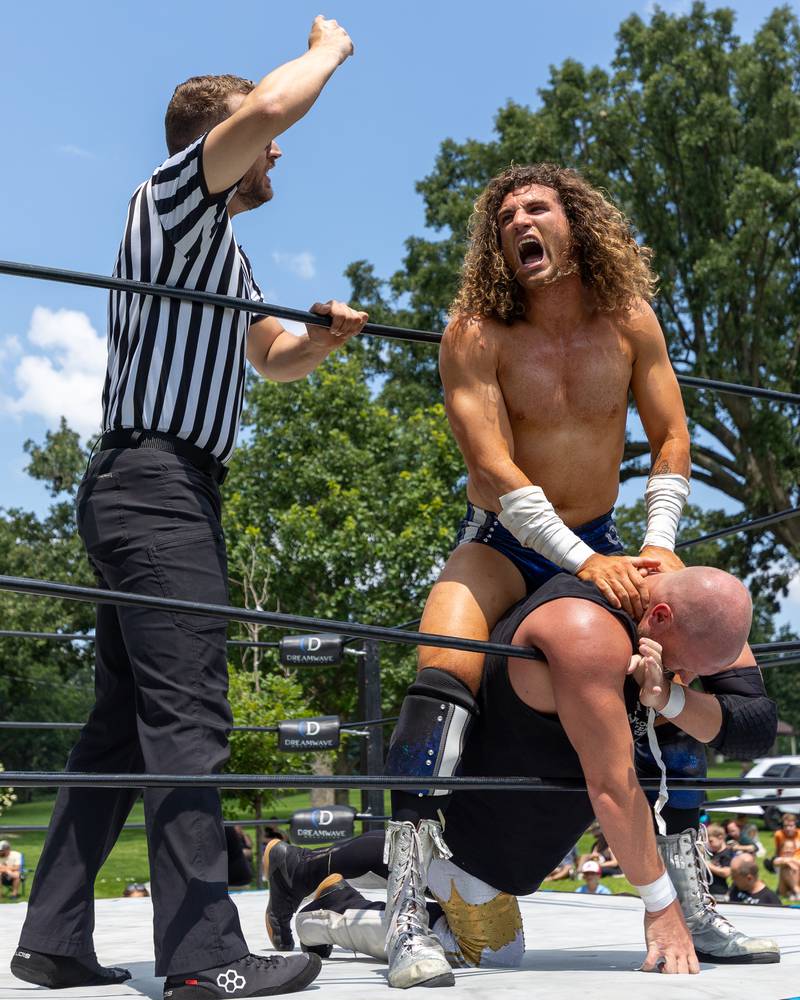 (left to right) Kevin Woods counts as Channing Thomas holds Hartebower's neck to rope at the Taste of the Illinois Valley DreamWave Wrestling event on Saturday, August 2, 2025 at Centennial Park in Peru.