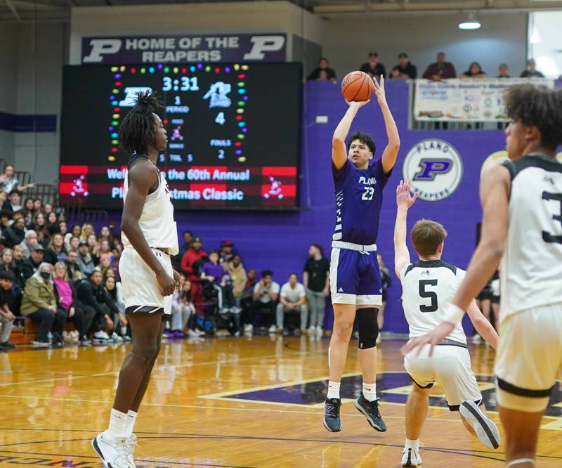 Plano's Isaiah Martinez (23) shoots a three pointer against Kaneland's Brad Franck (5) during a championship game of the 60th annual Plano Christmas Classic Basketball Tournament at Plano High School on Saturday, Dec 30, 2023.