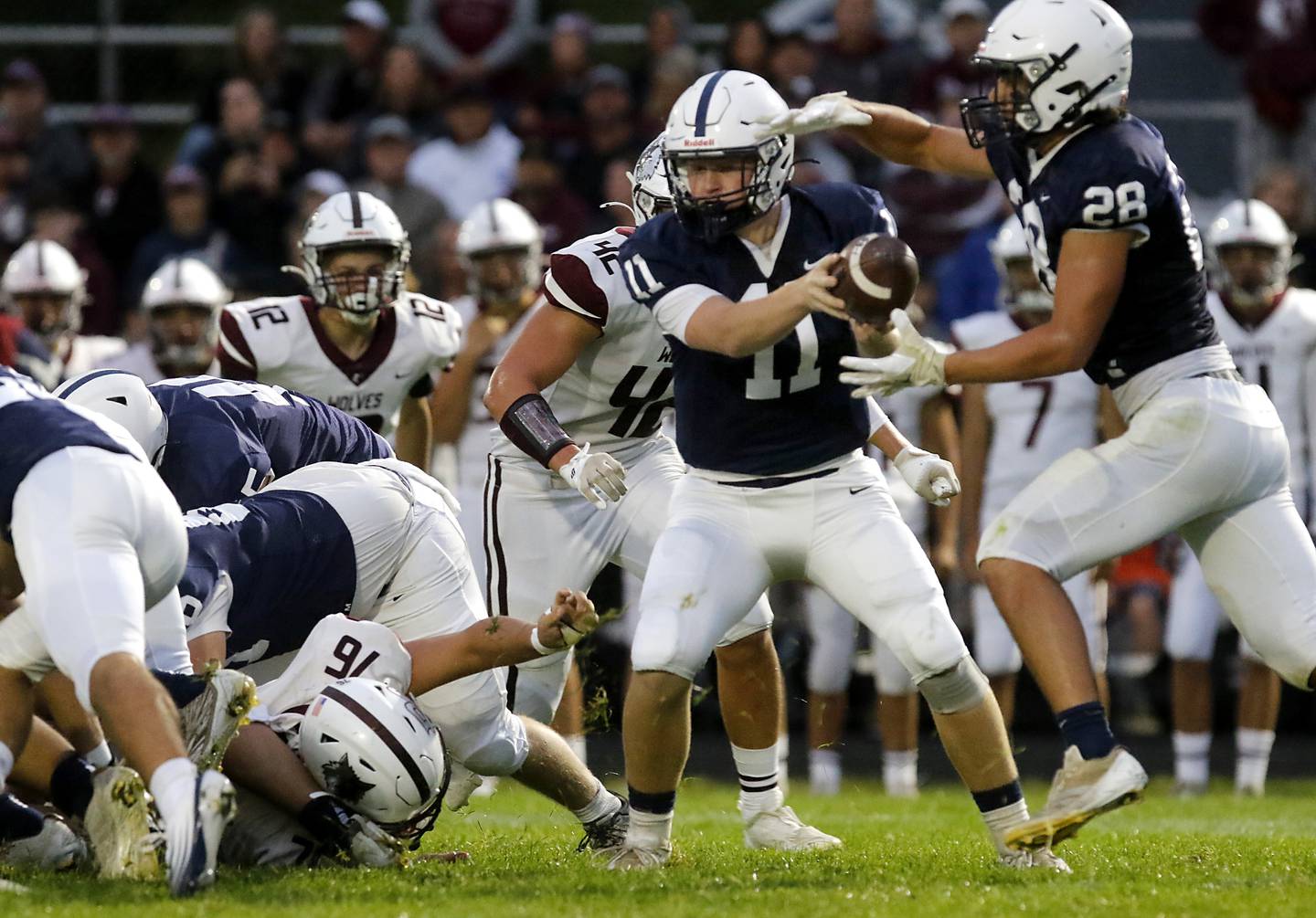 Cary-Grove's Jackson Berndt  hands the ball off to Brady Elbert during a Fox Valley Conference football game Prairie Ridge on Friday, Aug. 29, 2025, at Cary-Grove High School in Cary.