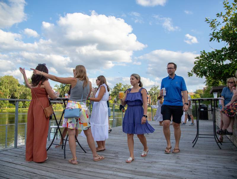Attendees enjoy time on the deck of the Lake Ellyn Boathouse during Thirsty Thursday on the Deck in Glen Ellyn on July 20, 2023.