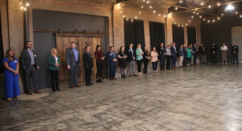 Recipients stand to be recognized during the Illinois Valley Chamber of Commerce 40 Under Forty awards banquet on Thursday, March 21, 2024 at Westclox in Peru.