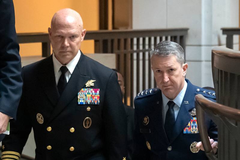U.S. Navy Adm. Frank M. Bradley, accompanied by Gen. Dan Caine, chairman of the Joint Chiefs of Staff, right, walks to a meeting with senators on Capitol Hill, Thursday, Dec. 4, 2025, in Washington. (AP Photo/Mark Schiefelbein)