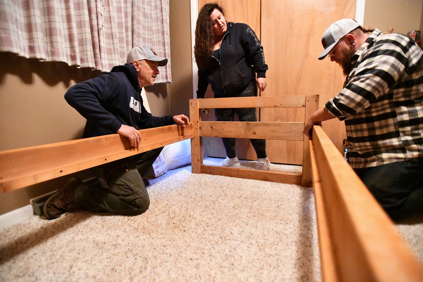 Kankakee Area Sleep in Heavenly Peace chapter president Tim Zydek, left, and volunteers Brandon Collins, right, and Nicole Elliot assemble the chapter's 1,002nd bed during a delivery in Kankakee on Nov. 30, 2023, as the organization passed the milestone of 1,000 beds delivered.