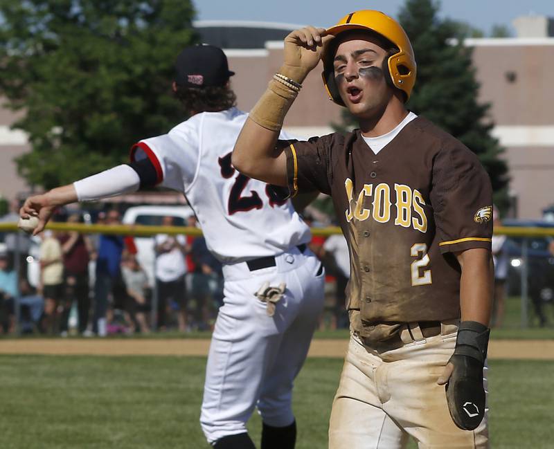 Jacobs's Nick Gottfried reacts to being tag out diving back to first base during a IHSA Class 4A baseball sectional semi-final baseball game between Jacobs and Huntley at Jacobs High School in Algonquin.